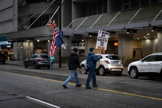 January 11, 2026, Vancouver, Bc, CANADA: People walk with signs during an Ice Out For Good rally outside of the U.S. Consulate General office in Vancouver, on Sunday, January 11, 2026. Vancouver CANADA  - ZUMAc35_ 20260111_zaf_c35_043 Copyright: xEthanxCairnsx