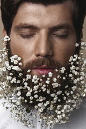 Kreatives Porträt eines jungen schönen Mannes mit einem mit Blumen geschmückten Bart Creative Portrait of young beautiful man with a beard decorated with flowers Copyright: imageBROKER Multipedia ibliqx16078819.jpg ,model released, Symbolfoto ,property released