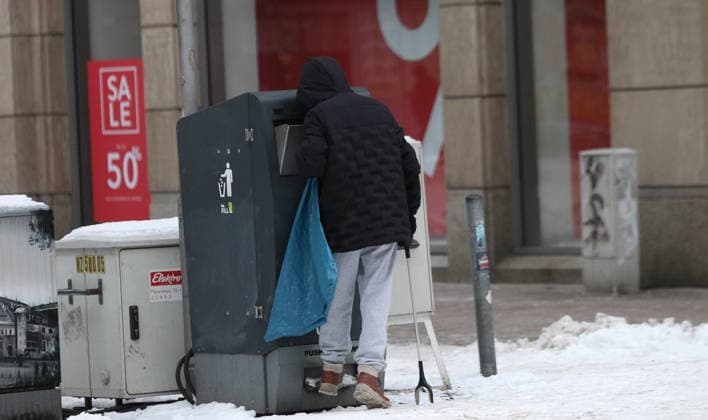 Ein Mann durchwühlt mit einer Greifzange in der Spitalerstraße Müllbehälter nach Pfandflaschen und Pfanddosen. Altstadt Hamburg *** A man rummages through garbage bins for returnable bottles and cans in Spitalerstraße Altstadt Hamburg