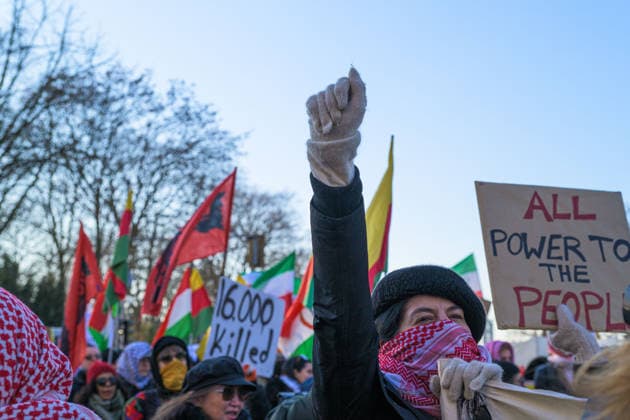 January 18, 2026, Berlin, Berlin, Germany: A demonstrator holds their fist up high while the slogan Jin Jiyan Azadi (Kurdish for Woman, Life, Freedom) is heard on Jan. 18, Berlin, Germany. People gatherered at Berlin s Brandenburg Gate to demonstrate and march to Neptune s Fountain against the Islamic Regime, the exiled crown prince (Reza Pahlavi) and Trump s decision to intervene. Berlin Germany - ZUMAk201 20260118_zip_k201_004 Copyright: xNikosxKanistrasx