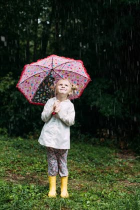 IMAGO Creative, Jahreszeit Sommer, Regen, Sommerregen Happy little girl holding a colorful umbrella in the rain McClure, Illinois, United States CR_WEKW260120-1945723-01 ,model released, Symbolfoto