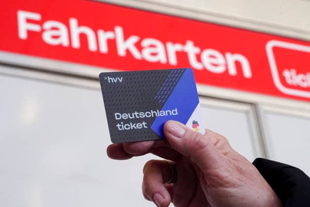 cntv Deutschlandtiket in your hand in front of HVV Bus und Bahnen Deutscxhe Bahn Deutschlandticket is a monthly subscription for the entire German public transport system OEPNV public transport buses, streetcars, underground trains, suburban trains, REs, RB It costs 63.00 euros per month and passenger since January 2026 and is valid throughout Germany Hamburg Germany