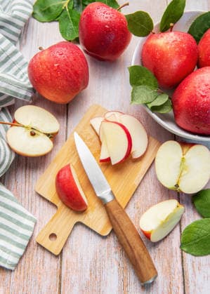 Fresh red apples slicing on a wooden cutting board, preparing healthy fruit snack Model Released OlenaRudo_ID32802_1116745_027 Copyright: xOlenaxRudox RECORD DATE NOT STATED