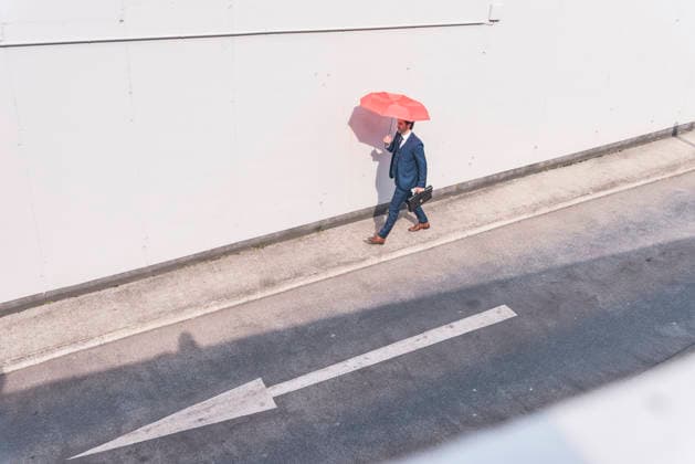 Businessman walking outdoors with umbrella on urban road with arrow model released, Symbolfoto, UUF36167