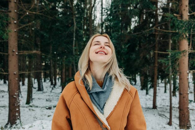 Smiling woman enjoying fresh air in winter forest wearing coat model released, Symbolfoto, VSNF04521