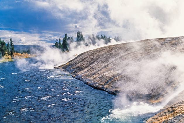 Heißes Wasser aus einer heißen Quelle fließt hinunter in einen Fluss im Yellowstone-Nationalpark. Hot water from a hot spring running down in a to a river in Yellowstone (License=RF) Copyright: xZoonar.com Larsxjohanssonx 24509982