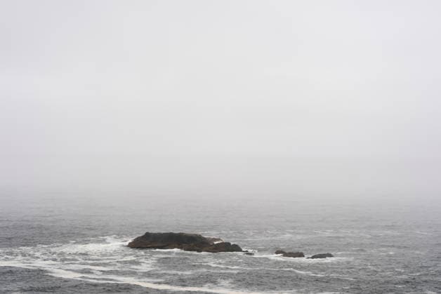 Kuestenlandschaft mit kleinem Felsen im Nebel auf Chiloe (Chile, Patagonien): graues Meer mit niedrigen Wellen; dunkle Felsen kleine Insel im Dunst. Chiloe, 15.12.2025. Chiloe Chile *** Coastal landscape with small rock in the fog on Chiloe Chile, Patagonia gray sea with low waves dark rocks small island in the haze Chiloe, 15 12 2025 Chiloe Chile Copyright: xHaukexPfluegerx