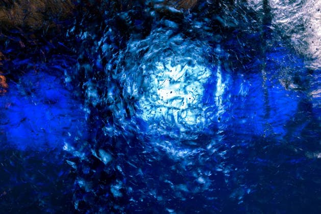 Transparentes Eis mit wunderschönen Mustern, blau hervorgehoben. Clear transparent ice with small bubbles illuminated with white and blue light. The structure of the ice creates fantastic patterns. (License=RF) Copyright: xZoonar.com RaufxKarimovx 24485424