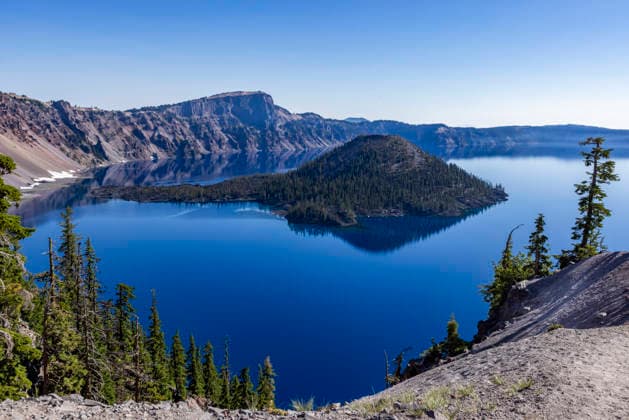USA, Oregon, Clear sky over calm Crater lake , 19.07.2024, model released, ,property released TTBB_tbs5132981.jpg, Outdoors,No People,Caldera,Day,Landscape - Scenery,Rock Formation,Tree,Lake,Cliff,Sunlight,Clear Sky,Water,Surface,Reflection,Scenics - Nature,Beauty In Nature,Tranquil Scene,Travel,Summer,Blue,Nature,Landscape,Crater Lake,Horizontal,Oregon,USA Copyright: xTetraxImages StevexSmithx
