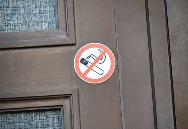 Rauchverbot in einem Gebäude, Aufkleber an der Eingangstür *** Smoking ban in a Building, Sticker to the Front door 1131607807