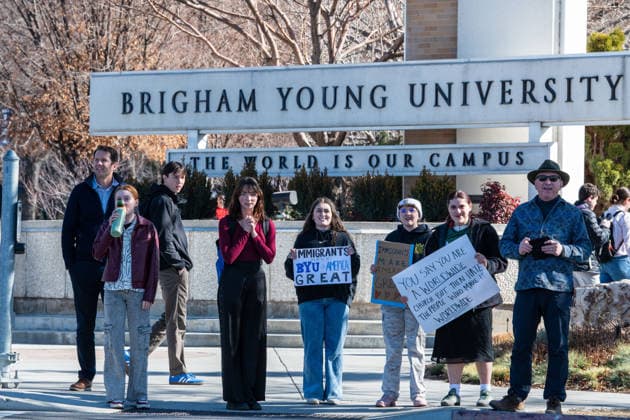 February 5, 2026, Provo, Utah, USA: People walk near the Brigham Young University entrance in Provo as demonstrators carrying signs gather to protest the presence of US Customs and Border Protection recruiters at a career fair held on the BYU campus. Provo USA - ZUMAm292 20260205_znp_m292_118 Copyright: xCharlesxMcClintockxWilsonx