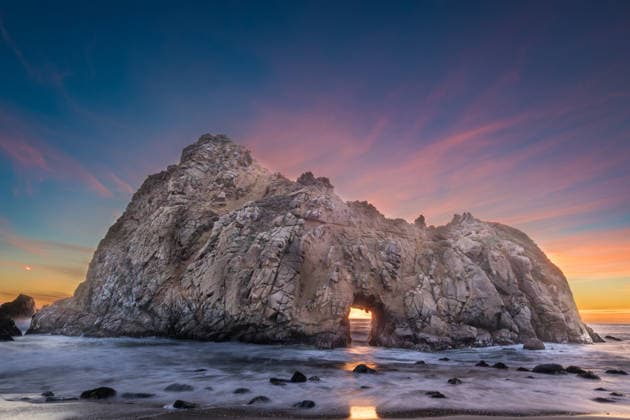 Creative Highlights World Majestic Sea Arch Rock Formation at Sunset Over Calm Coastal Wat Big Sur, California, United States R_NCJL260206-1961506-01