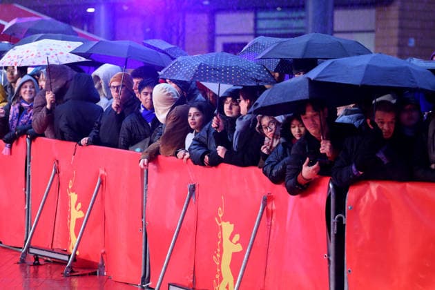 February 12, 2026, Berlin, Germany: Spectators shelter under umbrellas from the rain as they wait for guests to arrive on the red carpet at the opening ceremony of the 76th Berlin International Film Festival (Berlinale), which is Europe s first major film festival of the year, in Berlin. The festival runs from February 12 to 22, 2026. Berlin Germany  - ZUMAf146 20260212_zip_f146_070 Copyright: xRouzbehxFouladix