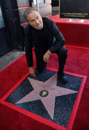 Italian actor Franco Nero kneels on his star during an unveiling ceremony honoring him with the 2,835th star on the Hollywood Walk of Fame in Los Angeles on Thursday, February 12, 2026.  LAP2026021208 JIMxRUYMEN
