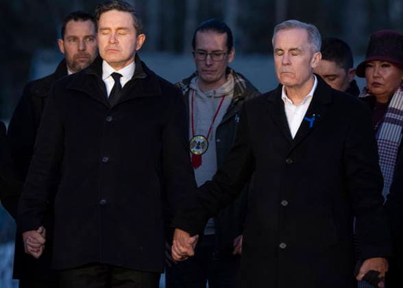 February 13, 2026, Tumbler Ridge, Bc, CANADA: Prime Minister Mark Carney, right, and Conservative Leader Pierre Poilievre join hands while attending a vigil for the victims of a mass shooting, in Tumbler Ridge, B.C., Friday, Feb. 13, 2026. Tumbler Ridge CANADA - ZUMAc35_ 20260213_zaf_c35_183 Copyright: xChristinnexMuschix