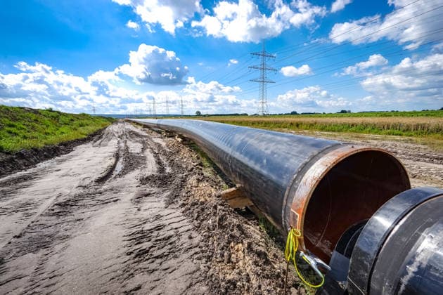 Construction of a gas pipeline, close-up of a section of the welded gas pipeline Construction of a gas pipeline through northern Germany to secure Germanys supply of natural gas and LNG Heavy equipment is needed to lower the huge pipes, which are welded together before being sunk in the previously excavate
