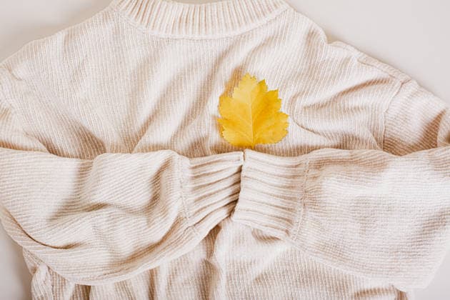 Gemütlicher Herbstpullover mit einem gelben Herbstblatt auf den Ärmeln, von oben auf das Herz gesehen Cozy autumn sweater holds with its sleeves a yellow autumn leaf on a heart top view (License=RF) Copyright: xZoonar.com ElenaxRuix 24648481