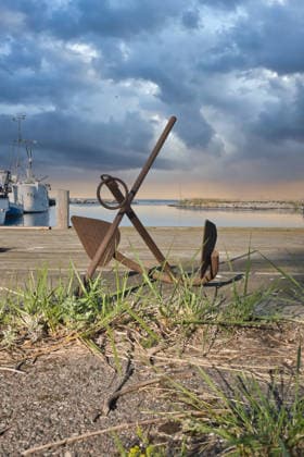 Rostiger Anker im Hafen vor einem dramatischen Himmel mit Küstenkulisse *** Rostiger Anchor at Port before a Dramatic Sky with Coastal scenery 1132203583