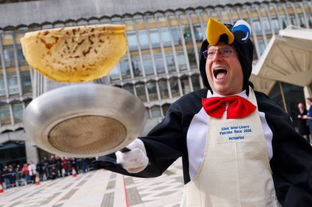 February 17, 2026, London, London, UK: London, UK. A participant in fancy dress flips a pancake during the Inter-Livery Pancake Race at Guildhall Yard in the City of London on Shrove Tuesday, raising funds for the Lord Mayors Charity. Members of the City Livery Companies take part in the annual event, also known as the Poulters Pancake Race, racing in ceremonial robes and fancy dress. The event has been held annually since 1983. London UK  - ZUMAl94_ 20260217_zaf_l94_039 Copyright: xDinendraxHariax