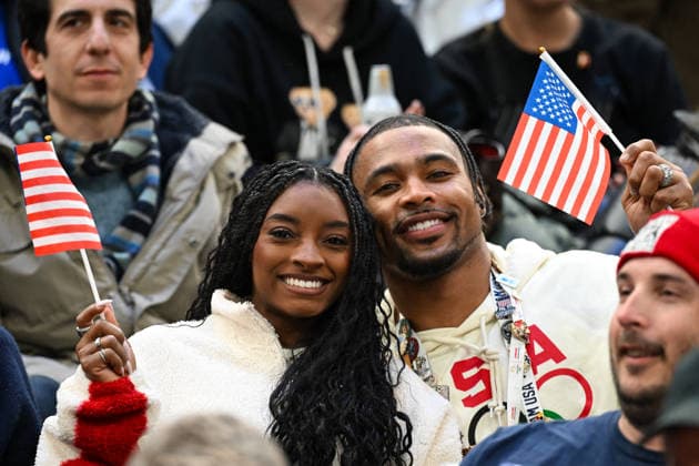 Winter Olympics - Simone Biles And Jonathan Owens At Milano Santagiulia Ice Hockey Arena American gymnast Simone Biles and husband Jonathan Owens look on while holding an american flag during the Men s Quarterfinals Playoff match between the United States and Sweden on day 12 of the Milano Cortina 2026 Winter Olympic games at Milano Santagiulia Ice Hockey Arena on February 18, 2026 in Milan, Italy. Photo by JMP ABACAPRESS.COM Milan Italy  Copyright: xJMP ABACAx
