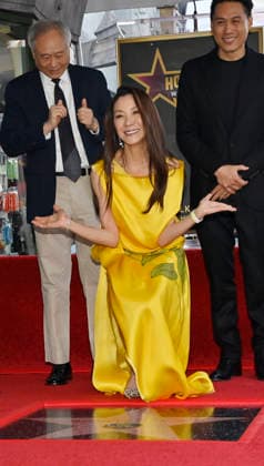 Actress Michelle Yeoh (C) reacts during an unveiling ceremony honoring her with the 2,836th star on the Hollywood Walk of Fame as directors And Lee (L) and John M. Chu look on in Los Angeles on Wednesday, February 18, 2026.  LAP2026021803 JIMxRUYMEN