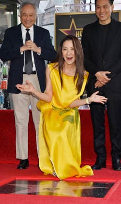 Actress Michelle Yeoh (C) reacts during an unveiling ceremony honoring her with the 2,836th star on the Hollywood Walk of Fame as directors And Lee (L) and John M. Chu look on in Los Angeles on Wednesday, February 18, 2026.  LAP2026021804 JIMxRUYMEN