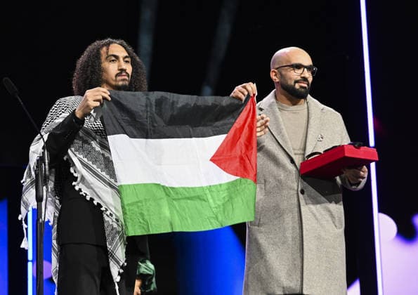 76th Berlin International Film Festival BERLIN, GERMANY - FEBRUARY 21: Director Abdallah Alkhatib (L) takes to the stage carrying the Palestinian flag after winning the Best Feature Film Award with his film Chronicles From the Siege at the 76th Berlin International Film Festival (Berlinale) in Berlin, Germany, on February 21, 2026. Halil Sagirkaya Anadolu Berlin Germany. Editorial use only. Please get in touch for any other usage.  Copyright: x2026xAnadoluxHalilxSagirkayax