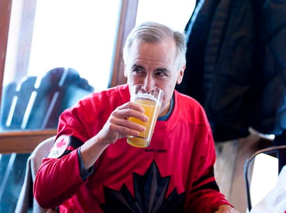 February 22, 2026, Chelsea, Pq, CAN: Prime Minister Mark Carney takes a sip of a zero-percent beer as he watches the gold medal men s ice hockey game between Canada and the United States at the 2026 Milan Cortina Winter Olympics at a pub in Chelsea, Que., on Sunday, Feb. 22, 2026. Chelsea CAN  - ZUMAc35_ 20260222_zaf_c35_051 Copyright: xJustinxTangx