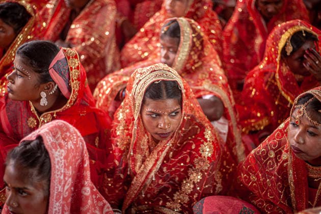 121 Couples Participate in Community-Funded Mass Wedding in Jharkhand, India - 22 Feb 2026 Brides dressed in traditional wedding attire wait for the start of a community-funded mass ceremony involving 121 couples. A community-funded mass wedding of 121 couples highlights the increasing reliance on collective ceremonies to bypass the prohibitive costs of traditional Indian marriages. These grassroots events offer a vital socio-economic lifeline, pooling local resources to provide financial relief for underprivileged families amid rising inflation. Gumla India Copyright: xYousufxSarfarazx xSOPAxImagesx MASS_WEDDING_JHARKHAND_YSARFARAZ-7