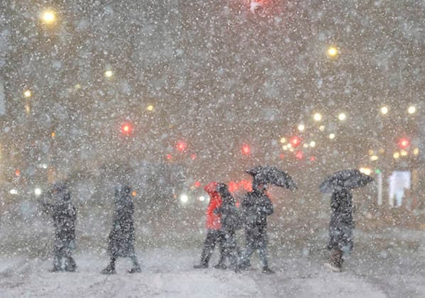 Pedestrians dressed for winter weather walk in Times Square while heavy snow falls when a major winter snow storm lands in New York City on Sunday, February 22, 2026. A major nor easter arrived Sunday in New York City and the Tri-State Area, bringing blizzard conditions, tropical storm-force wind gusts and potentially two feet of snow or more.  NYP20260222129 JOHNxANGELILLO