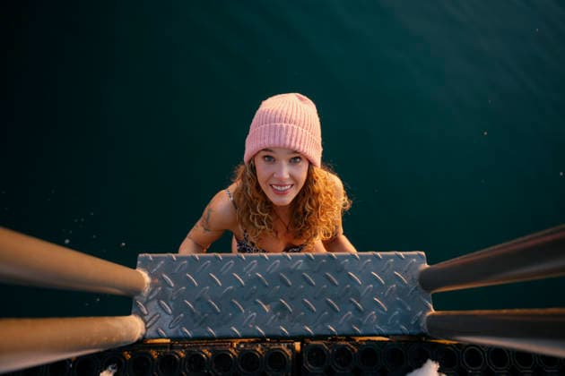 Smiling woman in hat climbing ladder after winter ice bath in lake model released, Symbolfoto property released, FLMZF02287