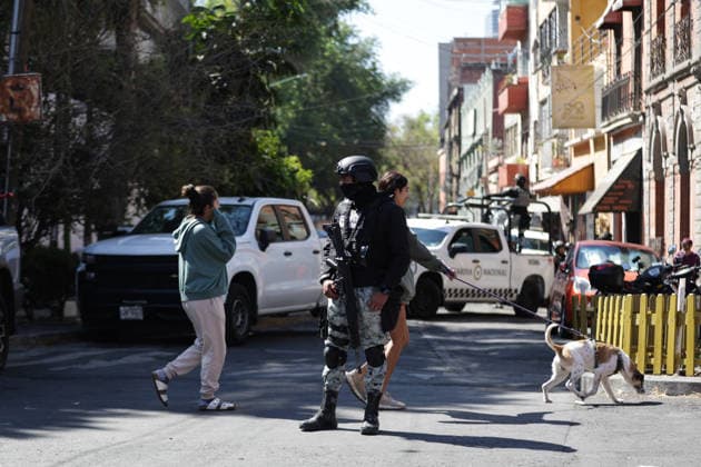 (260223) -- MEXICO CITY, Feb. 23, 2026 -- Security personnel guard on a street in Mexico City, Mexico, Feb. 23, 2026. Retaliation attacks from the Jalisco New Generation Cartel have left 27 security personnel dead, Mexico s Secretary of Security and Citizen Protection Omar Garcia Harfuch said Monday at a press conference. Mexican military forces launched an operation on Sunday and killed the Jalisco New Generation Cartel leader Nemesio Oseguera Cervantes, alias El Mencho. Members of cartels have set fire to cars and commercial facilities, and blocked roads. Some states closed schools on Monday. (Photo by Francisco Canedo Xinhua) MEXICO-MEXICO CITY-CARTEL-OPERATION-SECURITY FuxLangxisike¡¤kanieduo 