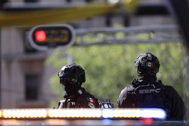 (260223) -- MEXICO CITY, Feb. 23, 2026 -- Security personnel guard on a street in Mexico City, Mexico, Feb. 23, 2026. Retaliation attacks from the Jalisco New Generation Cartel have left 27 security personnel dead, Mexico s Secretary of Security and Citizen Protection Omar Garcia Harfuch said Monday at a press conference. Mexican military forces launched an operation on Sunday and killed the Jalisco New Generation Cartel leader Nemesio Oseguera Cervantes, alias El Mencho. Members of cartels have set fire to cars and commercial facilities, and blocked roads. Some states closed schools on Monday. (Photo by Francisco Canedo Xinhua) MEXICO-MEXICO CITY-CARTEL-OPERATION-SECURITY FuxLangxisike¡¤kanieduo 