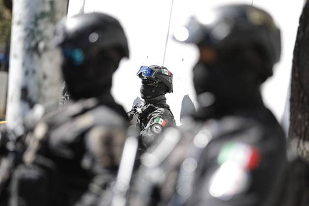 (260223) -- MEXICO CITY, Feb. 23, 2026 -- Security personnel guard on a street in Mexico City, Mexico, Feb. 23, 2026. Retaliation attacks from the Jalisco New Generation Cartel have left 27 security personnel dead, Mexico s Secretary of Security and Citizen Protection Omar Garcia Harfuch said Monday at a press conference. Mexican military forces launched an operation on Sunday and killed the Jalisco New Generation Cartel leader Nemesio Oseguera Cervantes, alias El Mencho. Members of cartels have set fire to cars and commercial facilities, and blocked roads. Some states closed schools on Monday. (Photo by Francisco Canedo Xinhua) MEXICO-MEXICO CITY-CARTEL-OPERATION-SECURITY FuxLangxisike¡¤kanieduo 