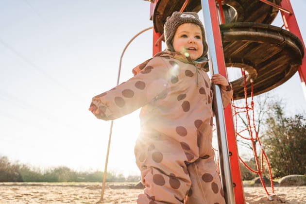 Child playing joyfully outdoors in winter clothes at playground model released, Symbolfoto, IHF02649