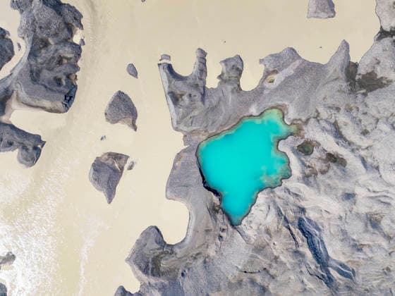 Top-down aerial view of turquoise meltwater pool at Vatnajökull glacier, Höfn Southern Region Iceland SMAF03279
