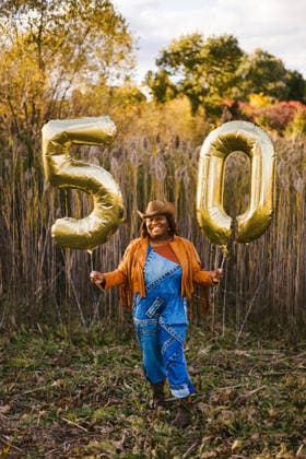 Black adult woman in cowboy outfit with 50 year old balloons Gurnee, Illinois, United States CR_WVNP260219-1960116-01 ,model released, Symbolfoto