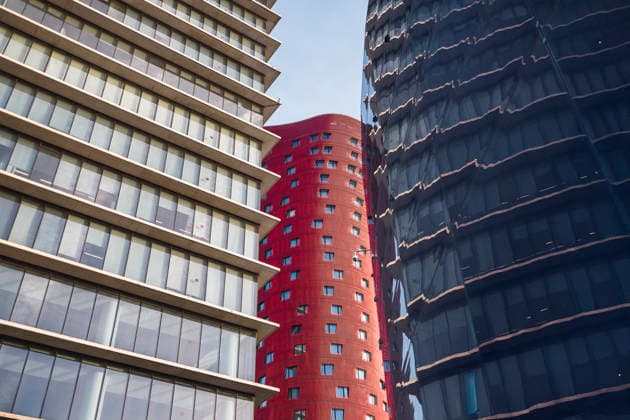 Modern office buildings with glass and red facade Modern office buildings with distinctive red and glass facades form a striking architectural contrast. Their geometric patterns create an urban visual appeal under a clear sky. Model Released DavidMunoz_ID33901_1193670_048 Copyright: xDavidxMunozx RECORD DATE NOT STATED