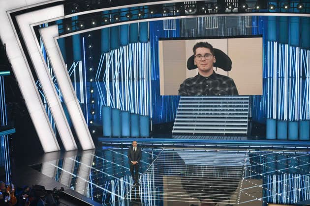 February 26, 2026, Sanremo, Italy: Paolo Sarullo (R) on the screen and Sanremo Festival host and artistic director Carlo Conti (L) on stage at the Ariston theatre during the 76th edition of the Sanremo Italian Song Festival, in Sanremo, Italy, 26 February 2026. The music festival will run from 24 to 28 February 2026. ANSA ETTORE FERRARI. Sanremo Italy  - ZUMAa110 20260226_zaf_a110_177 Copyright: xEttorexFerrarix