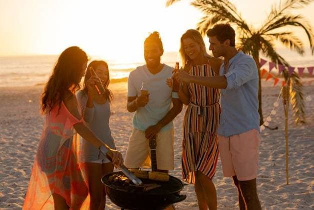 Mixed race friends doing barbecue on beach A multi-ethnic group of friends enjoying their time together on a beach during sunset, drinking beer and drinks, making a barbecue, model released, , property released, Cape Town, South Africa, 25.02.2020, 1345481.jpg, people,standing,drinking,beer,drink,bottle,making,barbecue,bbq,grilling,vegetables,real people,happy,smiling,friends,friendship,together,gen z,generation z,holidays,vacation,beach,sea,ocean,tropical,coast,summer,beachwear,seaside,enjoying,sun,leisure,freedom,free time,time off,relaxing,fun,escapism,weekend Young Adult,Woman,Female,Caucasian,Man,Male,Mixed-Race Outdoors,Day,Full frame background