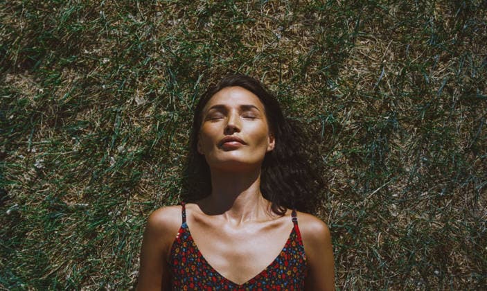 Serene woman relaxing and lying on a grass California City, California, United States CR_ARZH250523-1737202-01 ,model released, Symbolfoto