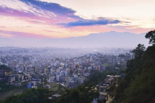 Weitläufiger Panoramablick auf den Sonnenuntergang über Kathmandu, Nepal, mit dichtem Stadtgebiet unter einem lebendigen Himmel und einer schwachen Himalaya Bergkulisse, die im Abendlicht leuchtet Expansive panoramic sunset view over Kathmandu, Nepal, with dense urban sprawl beneath a vibrant sky and faint Himalayan mountain backdrop glowing in evening light Copyright: imageBROKER EvaldasxMikoliunas ibxemi16709545.jpg