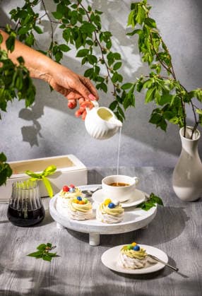 IMAGO Creative, Ostern, Bräuche, Osterbrunch Milch von Hand in Kaffee gießen mit Ostern-Baiser-Desserts Milch von Hand in Kaffee gießen mit Ostern-Baiser-Desserts (License=RF) Copyright: xZoonar.com VictoriaxKondysenkox(ArtSvitlynax 24752111