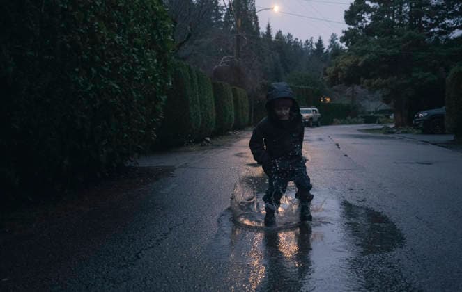 Young boy jumps and splashes in puddle on rainy day in the fall West Vancouver, British Columbia, Canada CR_PSFZ260305B-1958580-01 ,model released, Symbolfoto