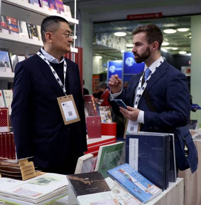 (260311) -- LONDON, March 11, 2026 -- People talk at the China Pavilion of the 2026 London Book Fair in London, Britain, March 10, 2026. At Olympia London, where the 2026 London Book Fair opened Tuesday, the China pavilion stands out not merely for its expansive footprint, but for the comprehensive publishing ecosystem it showcases. The Chinese publishing delegation has arrived with an impressive portfolio of over 4,000 titles and a packed schedule of more than 40 events. Spanning the three-day fair, the agenda ranges from high-profile new book launches and author talks to rights exchanges and industry forums. TO GO WITH Feature: Two-way street -- China s delegation highlights cultural synergy, tech fusion at London Book Fair ) BRI