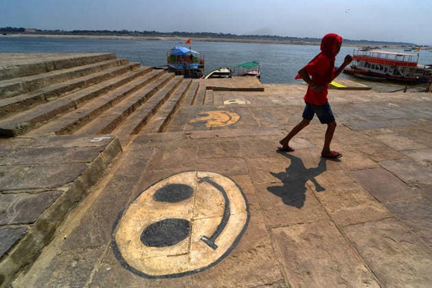 February 28, 2026, Varanasi, Uttar Pradesh, India: A man walks past a street mural depicting a smiley emoji. Varanasi India - ZUMAs197 20260228_aab_s197_064 Copyright: xAvishekxDasx