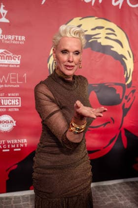 Datum: 13.03.26 Ort: Kitzbühel Im Bild: Brigitte Nielsen Er ist Kult blonde Haare, schwarze Sonnenbrille und eine unverwechselbare Jahrhundertstimme: Heino (87) blickt auf eine fast 70-jährige Karriere zurück. Doch nur wenige kennen die Geschichte hinter seiner berühmten dunklen Brille. Der Sänger, der bürgerlich Heinz Georg Kramm heißt, hat in seinem Leben über 55 Millionen Tonträger verkauft. Ob Schlager, Pop, Heavy Metal, Ballermann, Rap oder Klassik kaum ein Genre blieb ihm fremd. Bis heute steht der Kultstar auf der Bühne: Er tritt bei großen Festivals wie dem Parookaville vor Zehntausenden Fans genauso selbstverständlich auf wie bei klassischen Kirchenkonzerten, etwa in der Dresdner Kreuzkirche, oder bei Party xchristian esslerx