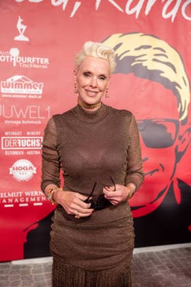 Datum: 13.03.26 Ort: Kitzbühel Im Bild: Brigitte Nielsen Er ist Kult blonde Haare, schwarze Sonnenbrille und eine unverwechselbare Jahrhundertstimme: Heino (87) blickt auf eine fast 70-jährige Karriere zurück. Doch nur wenige kennen die Geschichte hinter seiner berühmten dunklen Brille. Der Sänger, der bürgerlich Heinz Georg Kramm heißt, hat in seinem Leben über 55 Millionen Tonträger verkauft. Ob Schlager, Pop, Heavy Metal, Ballermann, Rap oder Klassik kaum ein Genre blieb ihm fremd. Bis heute steht der Kultstar auf der Bühne: Er tritt bei großen Festivals wie dem Parookaville vor Zehntausenden Fans genauso selbstverständlich auf wie bei klassischen Kirchenkonzerten, etwa in der Dresdner Kreuzkirche, oder bei Party xchristian esslerx