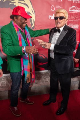 Datum: 13.03.26 Ort: Kitzbühel Im Bild: Roberto Blanco mit Heino Er ist Kult blonde Haare, schwarze Sonnenbrille und eine unverwechselbare Jahrhundertstimme: Heino (87) blickt auf eine fast 70-jährige Karriere zurück. Doch nur wenige kennen die Geschichte hinter seiner berühmten dunklen Brille. Der Sänger, der bürgerlich Heinz Georg Kramm heißt, hat in seinem Leben über 55 Millionen Tonträger verkauft. Ob Schlager, Pop, Heavy Metal, Ballermann, Rap oder Klassik kaum ein Genre blieb ihm fremd. Bis heute steht der Kultstar auf der Bühne: Er tritt bei großen Festivals wie dem Parookaville vor Zehntausenden Fans genauso selbstverständlich auf wie bei klassischen Kirchenkonzerten, etwa in der Dresdner Kreuzkirche, oder b xchristian esslerx