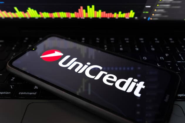 UniCredit Sees Up To â‚¬500 Million In AI Cost Cuts In Next Years The UniCredit logo appears on a smartphone screen, and a stock exchange curve chart displays as the background on a laptop computer screen in this photo illustration in Athens, Greece, on March 18, 2026. UniCredit SpA Chief Executive Officer Andrea Orcel states the bank is quantifying the impact of artificial intelligence at about EUR400 million to EUR500 million ($576 million) in net cost reductions over roughly five years, driven by efficiency gains across core processes such as lending, compliance, and client onboarding. Athens Greece  Copyright: xNikolasxKokovlisx originalFilename: kokovlis-notitle260318_npYRE.jpg